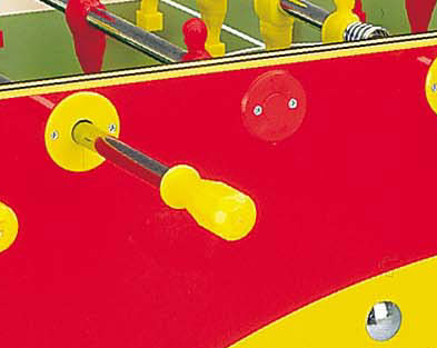 Nahaufnahme eines bunten Tischkickers mit gelben und roten Griffen sowie Spielfiguren auf einem grünen Spielfeld.